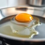 frying egg in stainless skillet